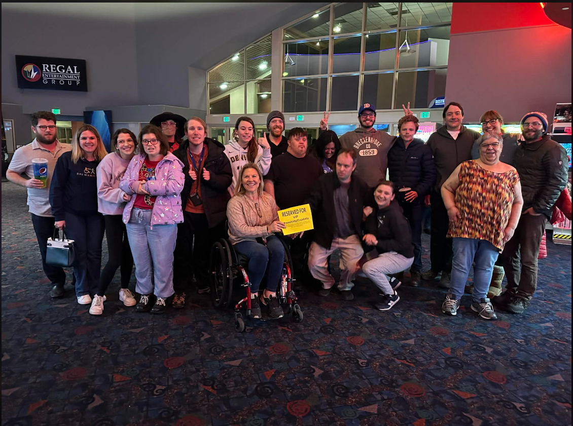 Brewability crew members, friends and supporters posing together in a movie theater lobby before a screening.
