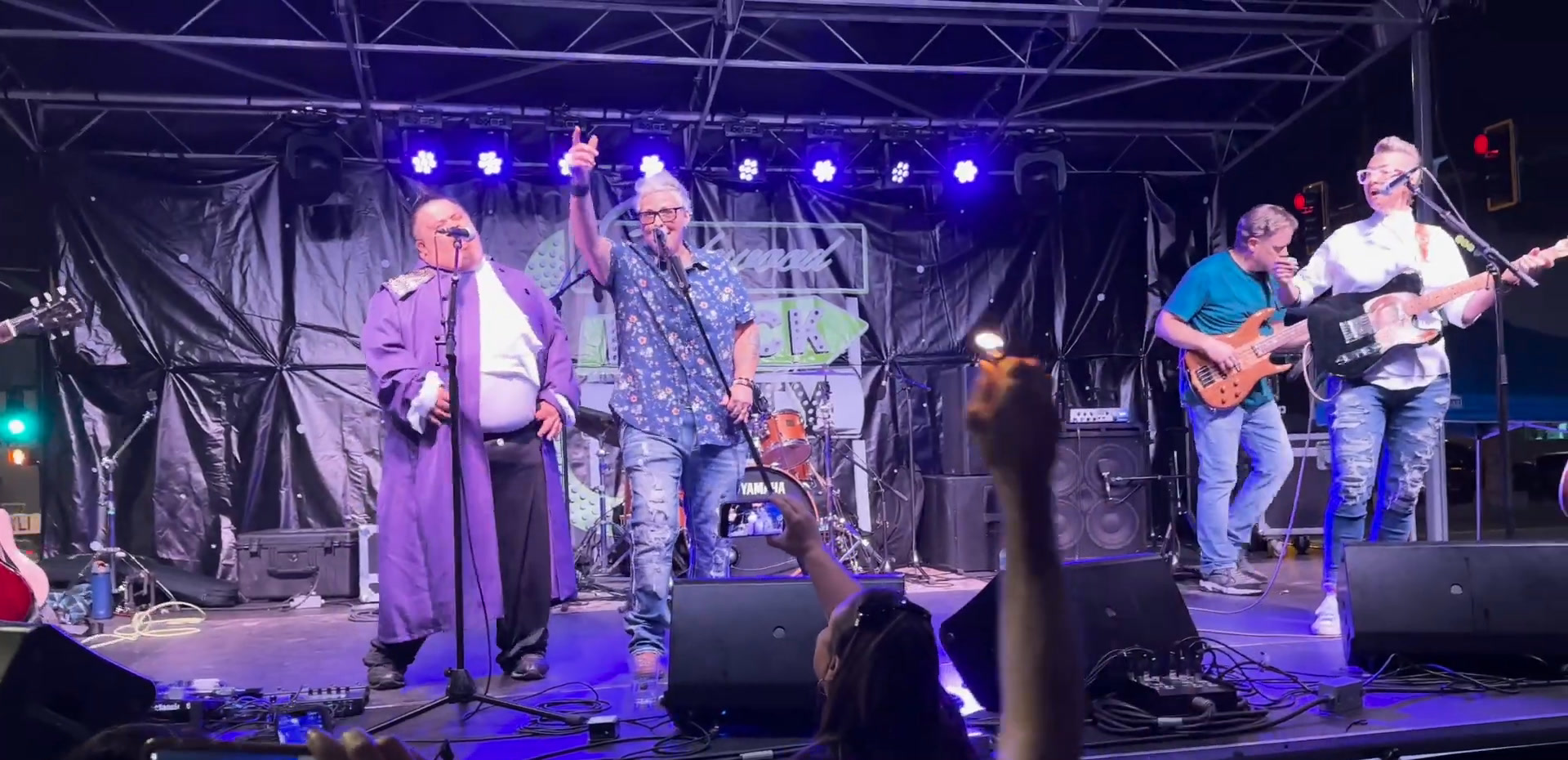 A band performing on the Brewability stage under purple and blue lights, with the audience watching.