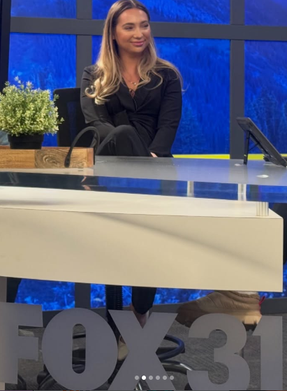 Jess seated at the FOX31 news desk during a studio visit.